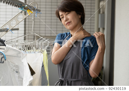 Housewife who feels stiff shoulders, stress and fatigue while doing housework Housewife who feels stiff shoulders, stress and fatigue while doing housework 92430119