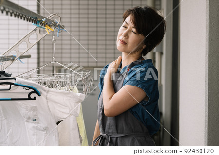 Housewife who feels stiff shoulders, stress and fatigue while doing housework Housewife who feels stiff shoulders, stress and fatigue while doing housework 92430120