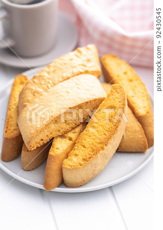 Sweet anicini cookies on plate. Italian biscotti with anise flavor on white table. Sweet anicini cookies on plate. Italian biscotti with anise flavor on white table. 92430545