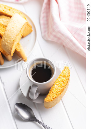 Sweet anicini cookies and coffee cup. Italian biscotti with anise flavor on white table. 92430549