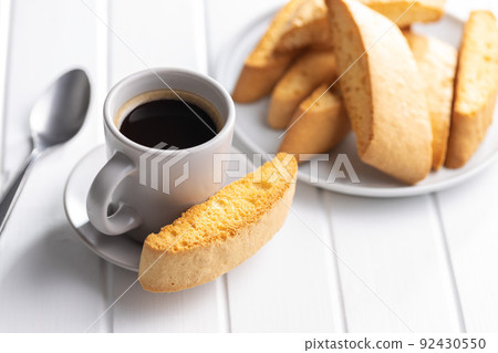 Sweet anicini cookies and coffee cup. Italian biscotti with anise flavor on white table. 92430550
