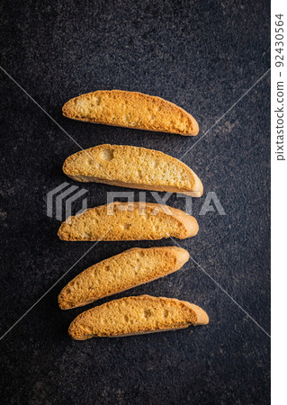 Sweet anicini cookies. Italian biscotti with anise flavor on black table Sweet anicini cookies. Italian biscotti with anise flavor on black table 92430564