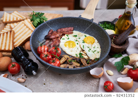 Fried eggs and bacon on a pan at domestic kitchen 92431352