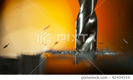 Drill bit drilling into aluminium pipe, macro shot. 92434554