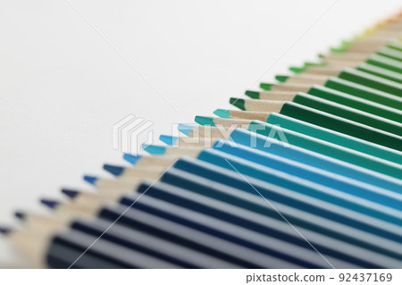 Colourful pencils perfectly arranged in row on white surface, macro of crayons for drawing Colourful pencils perfectly arranged in row on white surface, macro of crayons for drawing 92437169