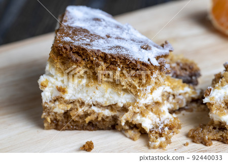 a piece of honey cake with vanilla cream and citrus tangerines 92440033