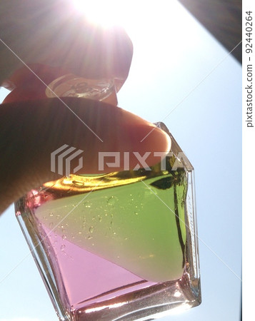 Color bottle held over the sun Color bottle held over the sun 92440264
