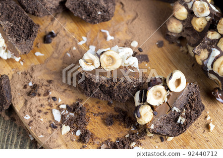 multicomponent cake made of caramel and nuts in chocolate 92440712