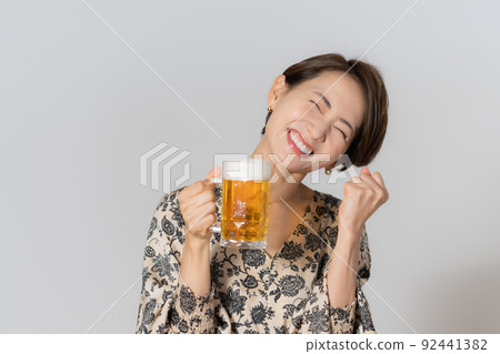 One middle-aged woman drinking beer on a white background 92441382