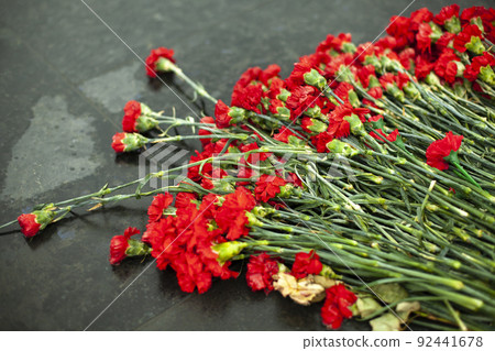 Flowers on memorial. Details of funeral decoration. Bouquet of flowers on grave. 92441678