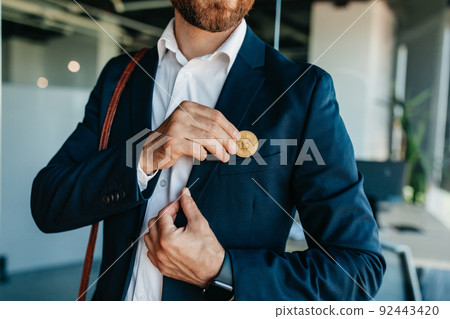 Future money and life with bitcoin concept. Investor man putting bitcoin to suit pocket, walking in office interior 92443420