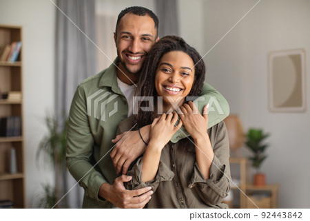 Joyful African American Husband Hugging Wife Standing At Home 92443842