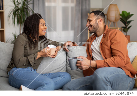 Loving African American Spouses Drinking Coffee And Talking At Home Loving African American Spouses Drinking Coffee And Talking At Home 92443874