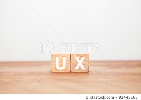 用戶體驗。用戶體驗。在木塊上繪製的 UX 字母。木桌背景。 92445165