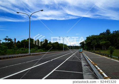 Sunny country road and parking space 92445320