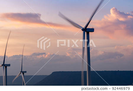 Wind energy. Wind power. Sustainable, renewable energy. Wind turbines generate electricity. Windmill farm on a mountain with sunset sky. Green technology. Renewable resource. Sustainable development. 92446979