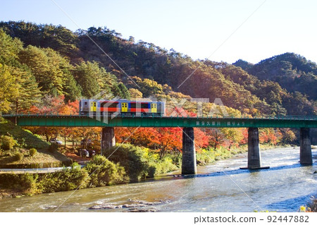 以山鶴山山鶴町的藍天和秋葉為背景，穿越久慈川鐵橋的列車 92447882