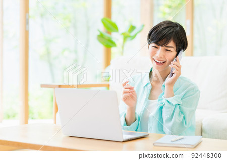 A young woman teleworking in the living room A young woman teleworking in the living room 92448300