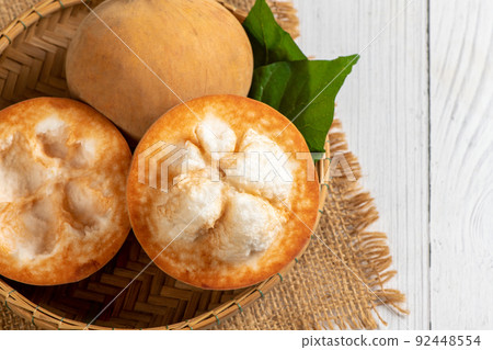 Top view of Fresh Santol fruits on bamboo basket and on white wood background, 92448554