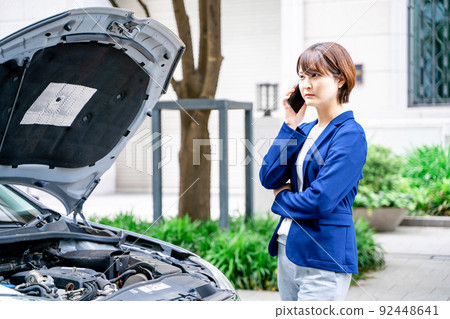 Business woman calling due to a car breakdown Business woman calling due to a car breakdown 92448641