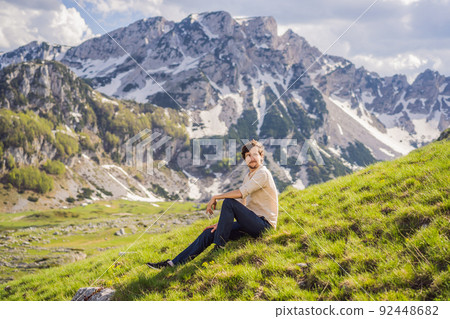 Man tourist in Mountain lake landscape on Durmitor mountain in Montenegro beautiful Durmitor National park with lake glacier and reflecting mountain Portrait of a disgruntled girl sitting at a cafe 92448682