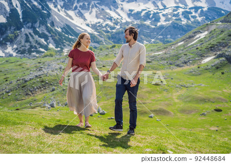Couple tourists man and woman in Mountain lake landscape on Durmitor mountain in Montenegro beautiful Durmitor National park with lake glacier and reflecting mountain Portrait of a disgruntled girl 92448684