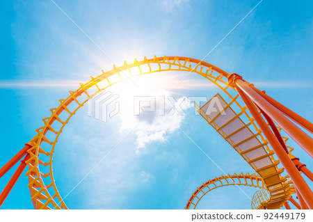 Rollercoaster railroad  track high to the sky roll bend and twist exciting machine fun people at theme park. 92449179