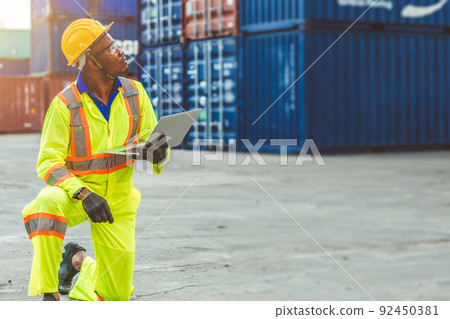 Foreman Containers Cargo Control Loading Staff with laptop computer black worker man work in port yard shipping. 92450381