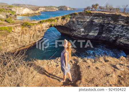 Young woman tourist near Broken Beach in Nusa Penida, Indonesia Angel's BillaBong Beach. Popular tourist destination Bali 92450422