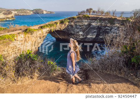 Young woman tourist near Broken Beach in Nusa Penida, Indonesia Angel's BillaBong Beach. Popular tourist destination Bali 92450447