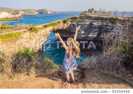 Young woman tourist near Broken Beach in Nusa Penida, Indonesia Angel's BillaBong Beach. Popular tourist destination Bali 92450448