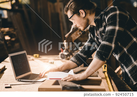 builder wood worker wooden furniture maker using laptop computer to design project 92450715