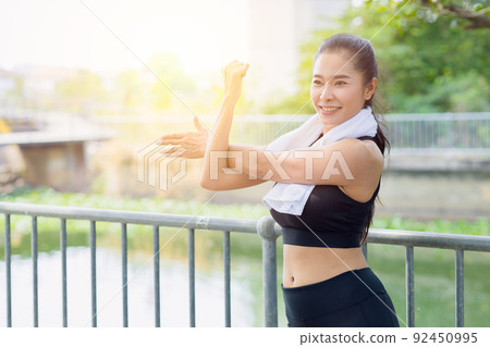 Asian healthy woman shoulder Stretching exercise at park outdoor morning Asian healthy woman shoulder Stretching exercise at park outdoor morning 92450995