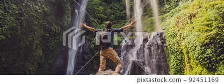 Man in turquoise dress at the Sekumpul waterfalls in jungles on Bali island, Indonesia. Bali Travel Concept BANNER, LONG FORMAT 92451169