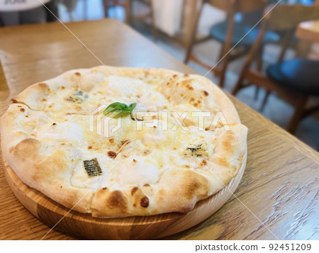 Four cheeses pizza on the table in the pizzeria. Creamy base, mozzarella, ricotta, dor blue and basil. selective focus Four cheeses pizza on the table in the pizzeria. Creamy base, mozzarella, ricotta, dor blue and basil. selective focus 92451209
