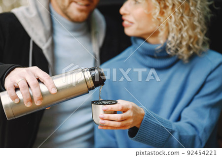 Cropped photo of a thermo cup in hands of couple 92454221