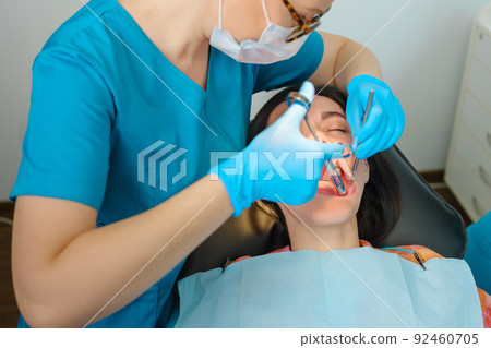 Female dentist with cartridge syringe injecting anesthetic medicine before teeth treatment 92460705