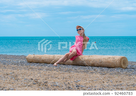 Log back sea coast girl little view nature blue beach, concept summer sun from lifestyle from background from, shoreline seaside. Childhood coastline, Log back sea coast girl little view nature blue beach, concept summer sun from lifestyle from background from, shoreline seaside. Childhood coastline, 92460783