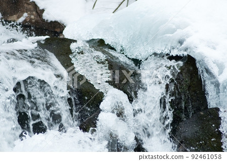 A small active waterfall. Clean mountain stream, snowy winter landscape, wildlife background 92461058