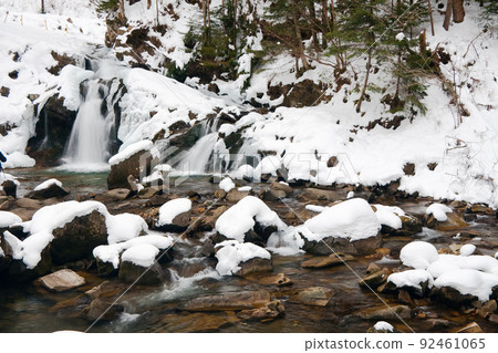 A small active waterfall. Clean mountain stream, snowy winter landscape, wildlife background A small active waterfall. Clean mountain stream, snowy winter landscape, wildlife background 92461065
