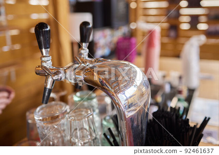 The beer taps in a pub. nobody. Selective focus. Alcohol concept. Vintage style. Beer craft. Bar table. Steel taps. Shiny taps. The beer taps in a pub. nobody. Selective focus. Alcohol concept. Vintage style. Beer craft. Bar table. Steel taps. Shiny taps. 92461637