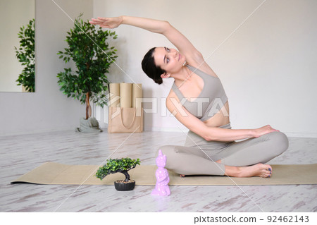A young woman with an athletic body is doing phineas on a yoga mat. A young woman with an athletic body is doing phineas on a yoga mat. 92462143