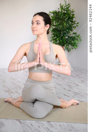 Young woman practices yoga in the studio. The girl meditates outdoors. 92462144