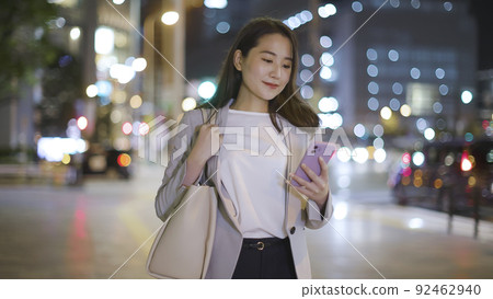 女商人在下班回家的路上看智能手機 92462940