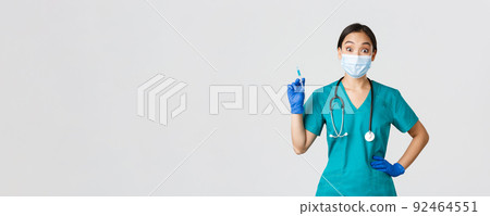 Covid-19, coronavirus disease, healthcare workers concept. Amused smiling asian physician, female doctor in medical mask and rubber gloves, prepared syringe with vaccine for shot, white background Covid-19, coronavirus disease, healthcare workers concept. Amused smiling asian physician, female doctor in medical mask and rubber gloves, prepared syringe with vaccine for shot, white background 92464551
