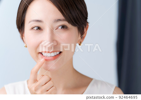 Woman checking teeth Woman checking teeth 92464695