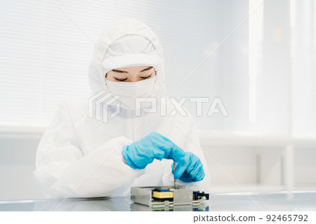 女性在潔淨室處理精密設備 女性在潔淨室處理精密設備 92465792