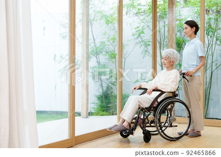 Caregiver and woman in a wheelchair 92465866