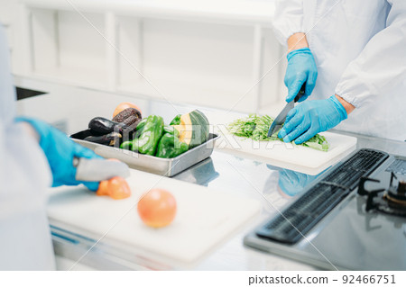 Men and women who cut vegetables in a clean suit (food processing / hand) 92466751