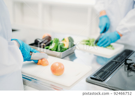 Men and women who cut vegetables in a clean suit (food processing / hand) Men and women who cut vegetables in a clean suit (food processing / hand) 92466752